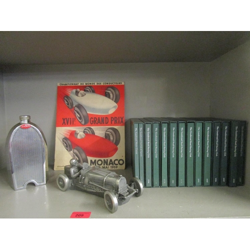 209 - A selection of motor racing memorabilia to include a flask in the form of a Bugatti car radiator, a ... 