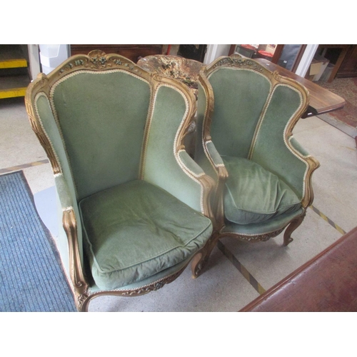 269 - A pair of late 19th century French gilt wood armchairs having applied floral moulding and on short c... 