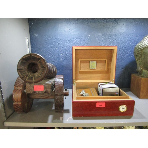 304 - A Humidor with various smoking accessories and a wooden model of a canon
Location: 7.1