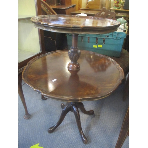 82 - An early 20th century mahogany two tier dumb waiter having pie crust border and standing on four cab... 