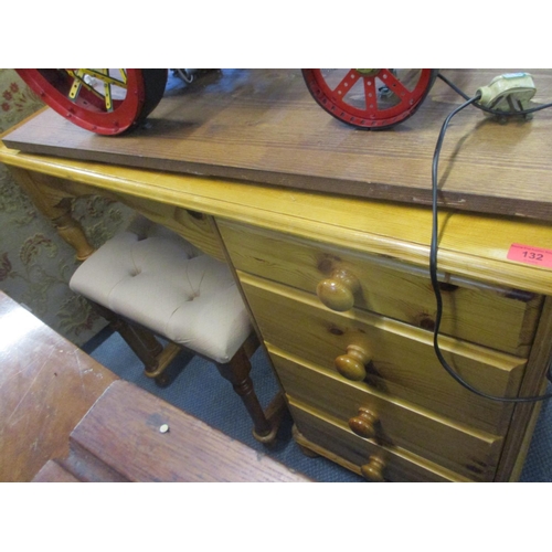 132 - A modern pine dressing table with four graduated side drawers on bun feet, along with a dressing tab... 