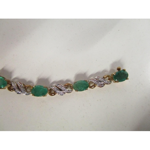 282 - 9ct yellow gold emerald and diamond line bracelet set with oval-cut emeralds and round-cut diamonds,... 