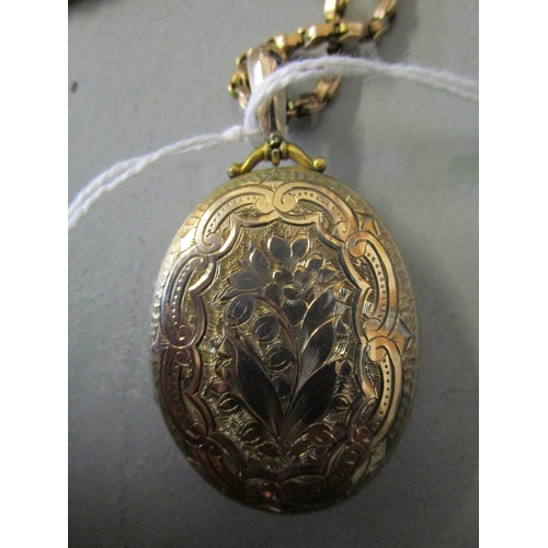 311 - A Victorian/Edwardian gold coloured pendant locket with floral engraved decoration, on a yellow meta... 