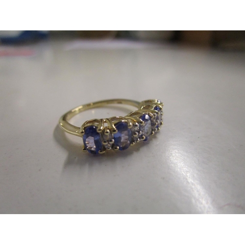 321 - 9ct yellow gold ring set with oval-cut tanzanites and round-ct white sapphires