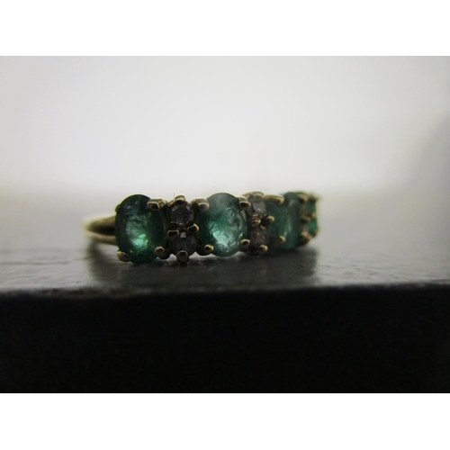 330 - 9ct yellow gold ring set with oval-cut emeralds and round-cut diamonds, boxed