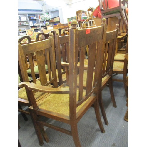 396 - Circa 1900, six standard chairs, one carver and one stool, all in oak with rush seats, the carver in... 