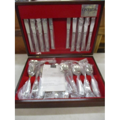 61 - A modern Oneida eight setting stainless steel cutlery set purchased in 1996, unused, housed in a mod... 