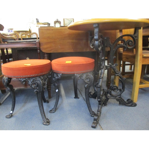 160 - A pub style circular table above ornate wrought iron stand and two similar style stools