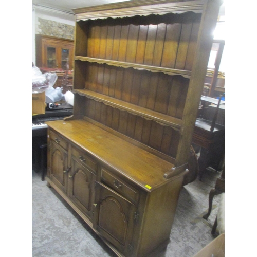 68 - A reproduction oak dresser having a plate rack above three drawers and cupboards below 199.5cm h x 1... 