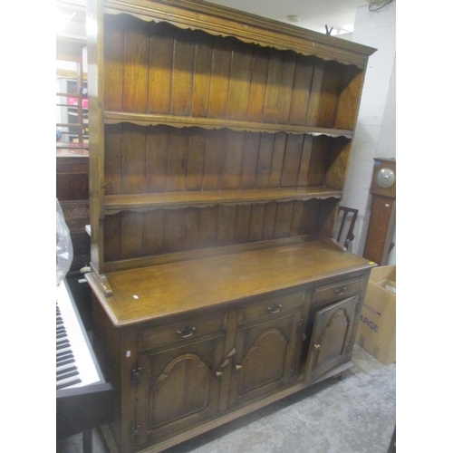 68 - A reproduction oak dresser having a plate rack above three drawers and cupboards below 199.5cm h x 1... 