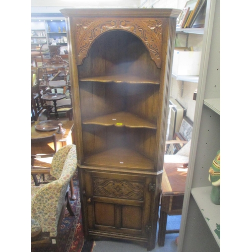 69 - A reproduction oak corner cabinet having open shelves above a single door 178.5cm h x 67cm w