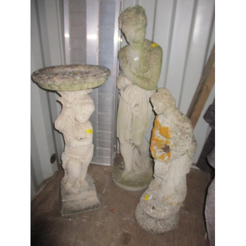 150 - Two weathered concrete garden statues of classically dressed women, and a bird bath of a putti holdi... 