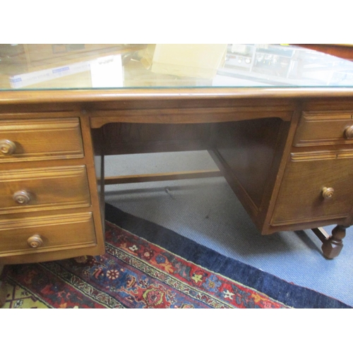 306 - An Ercol twin pedestal desk housing a file drawer and four short drawers