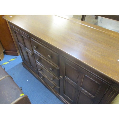 316 - An Ercol dresser base with four central short drawers flaked by fielded cupboards