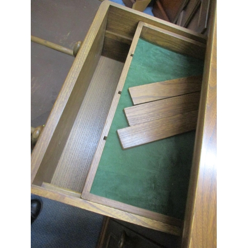 316 - An Ercol dresser base with four central short drawers flaked by fielded cupboards