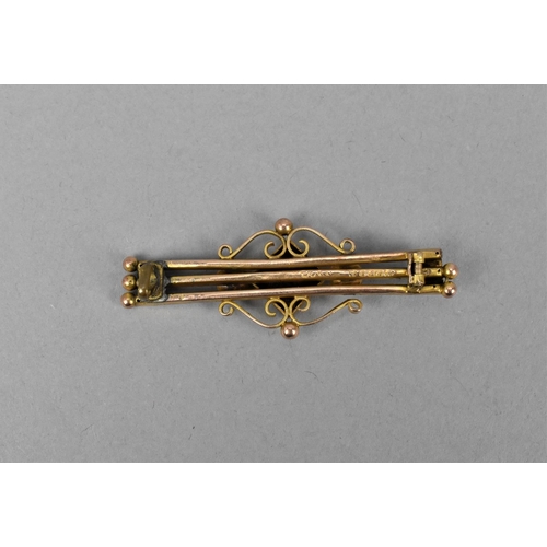 25 - A 9ct gold Edwardian bar brooch, inset with a central old cut diamond and flanked with a ruby to one... 