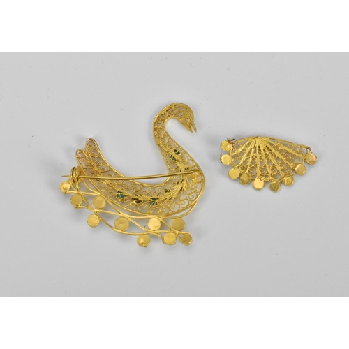 52 - A gold and turquoise brooch in the shape of a swan swimming, designed with filigree scrolls and turq... 