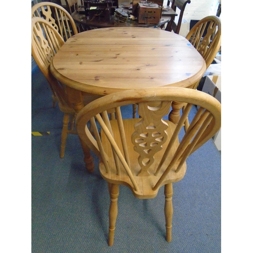 74 - A pine extending kitchen table with rise and fall leaf, and four winder wheel back style kitchen cha... 