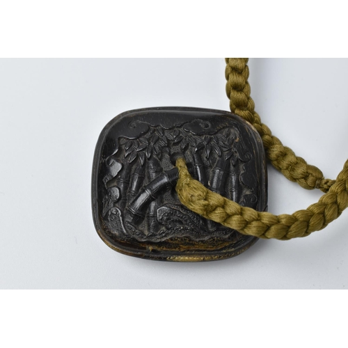 26 - A Japanese pressed horn Manju, 19th century, of rectangular form with carved samurai and tiger to on... 