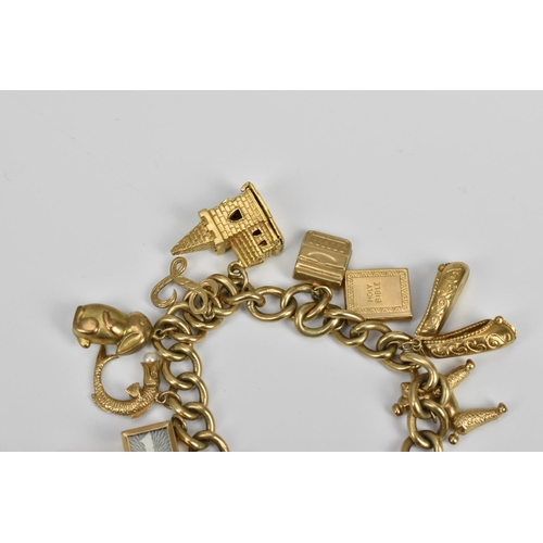 190 - A 9ct gold charm bracelet, the cable chain holding various miniature charms of buildings, animals, s... 