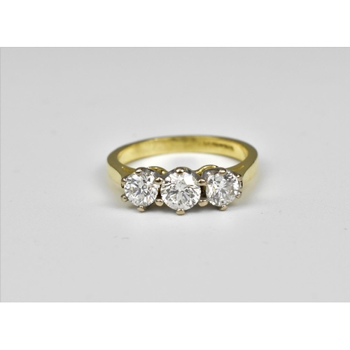 198 - An 18ct yellow gold and three stone diamond ring, the central diamond around 0.26 carat, the shank m... 