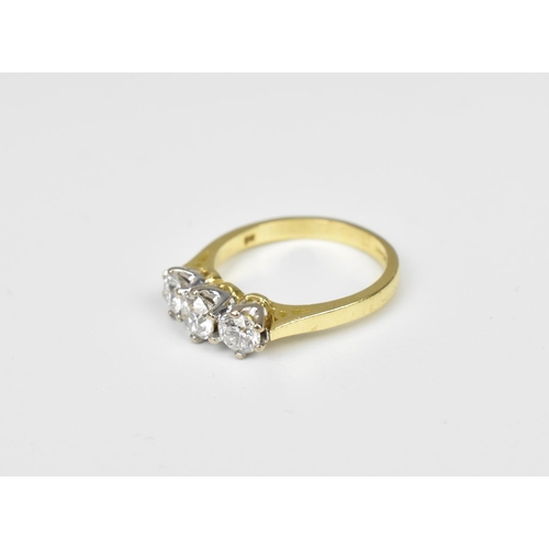 198 - An 18ct yellow gold and three stone diamond ring, the central diamond around 0.26 carat, the shank m... 