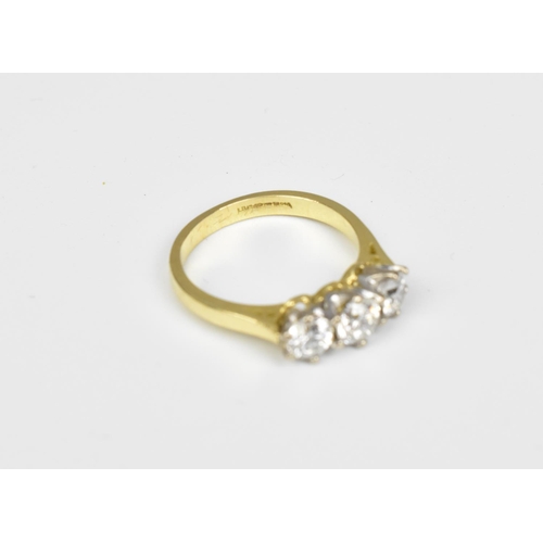 198 - An 18ct yellow gold and three stone diamond ring, the central diamond around 0.26 carat, the shank m... 