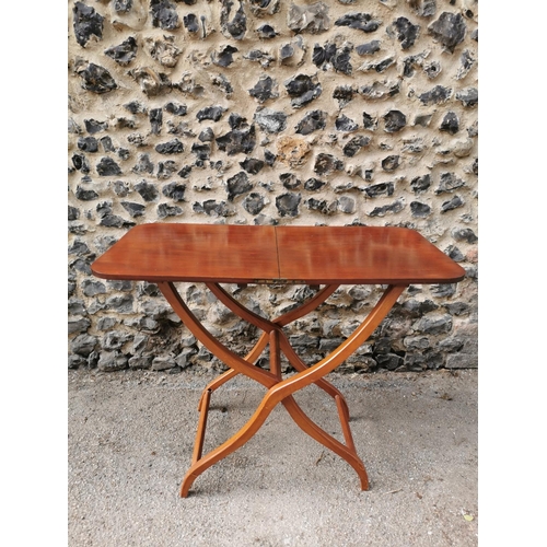 193 - A 19th century mahogany folding campaign or coaching table, raised on scissor action shaped x-frame ... 