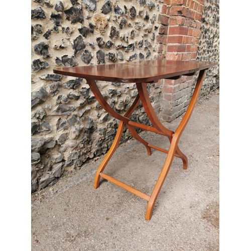 193 - A 19th century mahogany folding campaign or coaching table, raised on scissor action shaped x-frame ... 