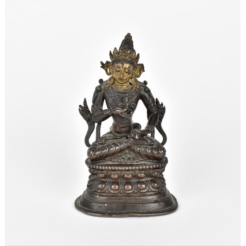 78 - A Sino-Tibetan bronzed copper alloy model of Tara Bodhisattva, sat in a lotus position holding a dor...