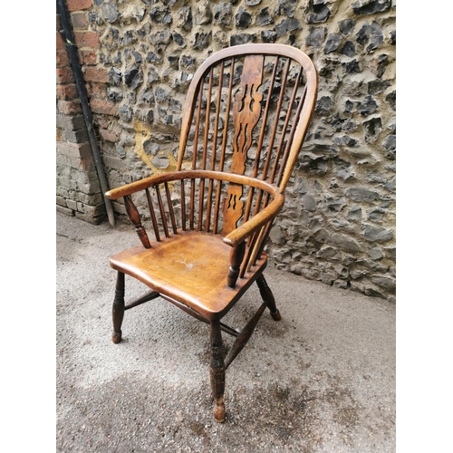 185 - A 19th century ash and elm windsor armchair, with hooped back with central pierced back, flanked wit... 