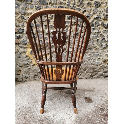 185 - A 19th century ash and elm windsor armchair, with hooped back with central pierced back, flanked wit... 