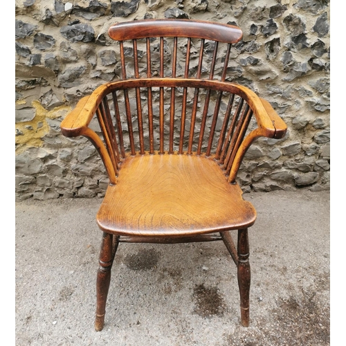 186 - A 19th century ash and elm windsor armchair, with  turned spindle back and broad arm rail, supported... 