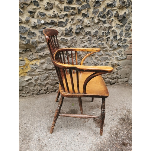 186 - A 19th century ash and elm windsor armchair, with  turned spindle back and broad arm rail, supported... 