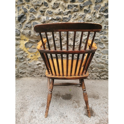 186 - A 19th century ash and elm windsor armchair, with  turned spindle back and broad arm rail, supported... 