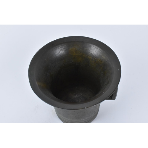 198 - An 18th century or earlier Middle Eastern bronze mortar and pestle, modelled with flanged decoration... 