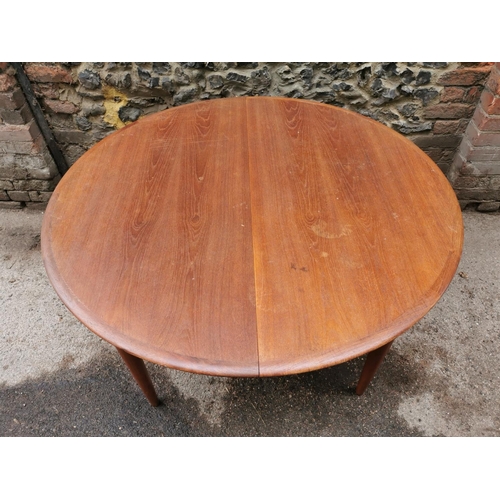 44 - A 1960s Danish teak extending table and chairs by Skovmand & Andersen, the circular table with two a... 