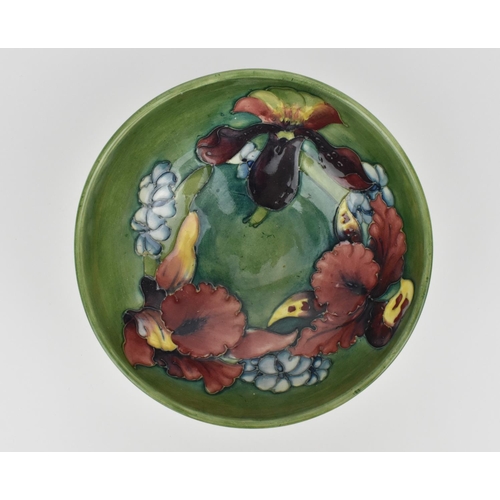 170 - A Walter Moorcroft Orchid pattern porcelain bowl, on a green ground with tubelining decoration, the ... 