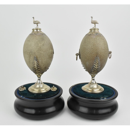 194 - A pair of late 19th/early 20th century carved Australian emu eggs mounted with white metal surmount ... 