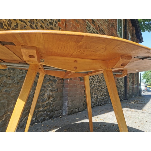 199 - A blonde elm Ercol drop leaf circular dining table, together with six candlestick lattice beech and ... 