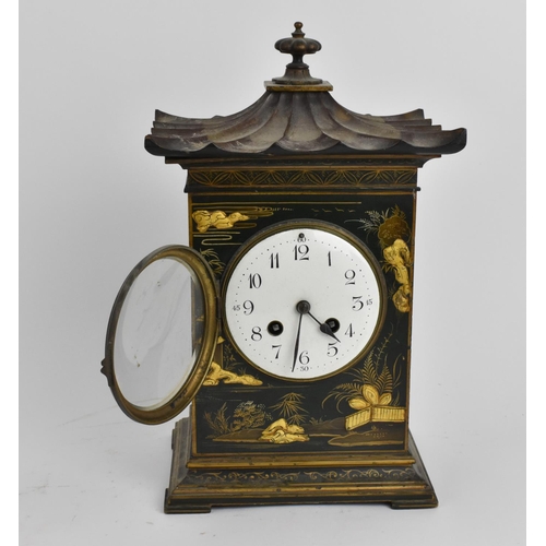 64 - An early 20th century Japanned mantle clock in the form of a pagoda having an enamel dial with Arabi... 