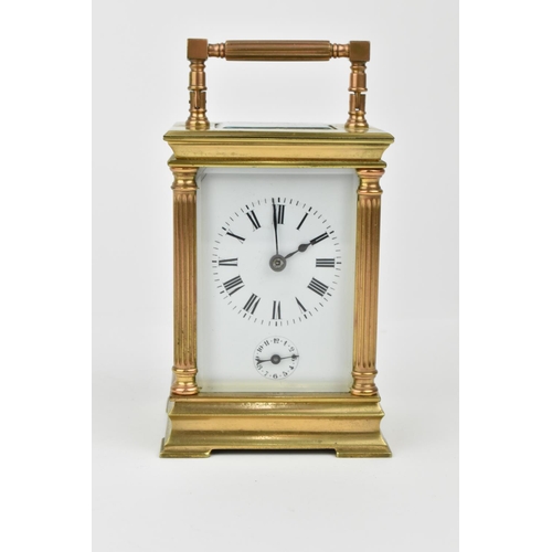 216 - A French brass cased carriage clock with alarm. Supported by four columns. Having a white enamel dia... 