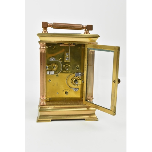 216 - A French brass cased carriage clock with alarm. Supported by four columns. Having a white enamel dia... 