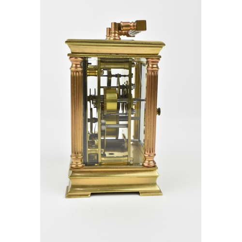 216 - A French brass cased carriage clock with alarm. Supported by four columns. Having a white enamel dia... 