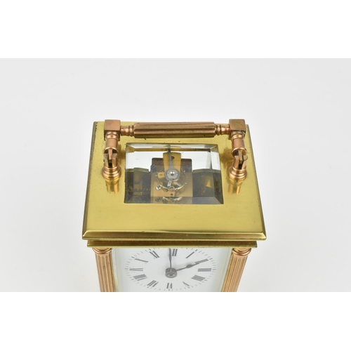 216 - A French brass cased carriage clock with alarm. Supported by four columns. Having a white enamel dia... 