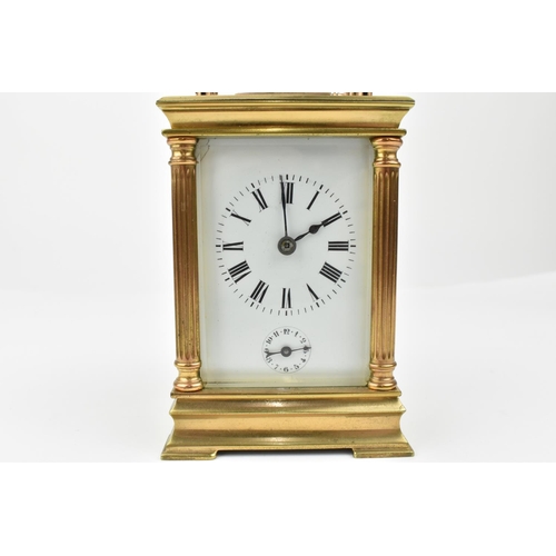 216 - A French brass cased carriage clock with alarm. Supported by four columns. Having a white enamel dia... 