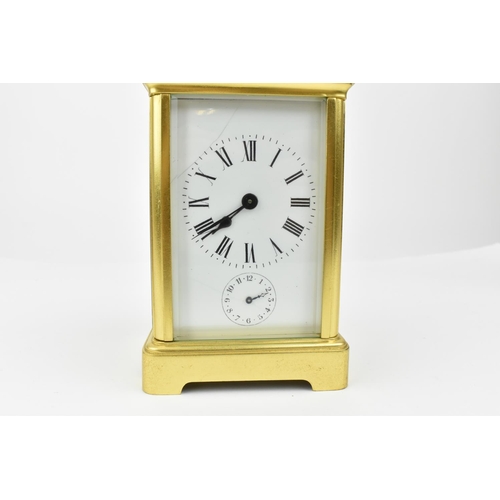 220 - A brass cased carriage clock with alarm. Having a white enamel dial with Roman numerals and Arabic s... 