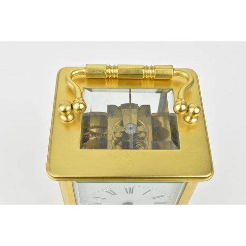 220 - A brass cased carriage clock with alarm. Having a white enamel dial with Roman numerals and Arabic s... 