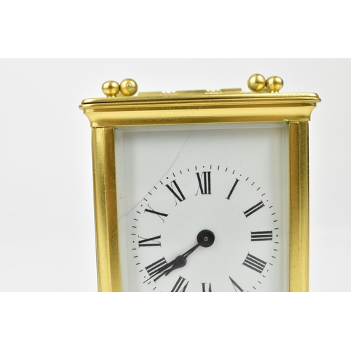 220 - A brass cased carriage clock with alarm. Having a white enamel dial with Roman numerals and Arabic s... 