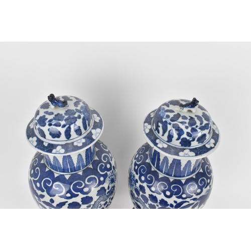 68 - A pair of Chinese Qing dynasty blue and white porcelain lidded vases, 19th century, of baluster shap... 